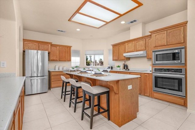 431 S Fowler Ave, Fresno, CA 93727 - kitchen featuring stainless steel appliances, under cabinet range hood, a center island, a kitchen breakfast bar, and light countertops