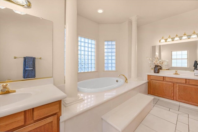 431 S Fowler Ave, Fresno, CA 93727 - bathroom featuring two vanities, a bath, tile patterned flooring, and decorative columns