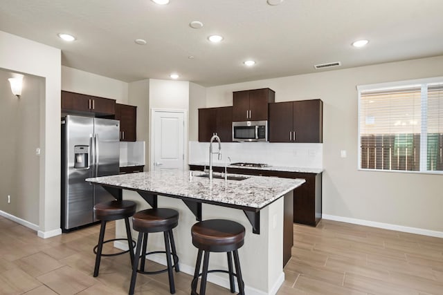 503 Cathedral Ct S, Madera, CA 93636 - kitchen featuring appliances with stainless steel finishes, a kitchen bar, dark brown cabinets, and recessed lighting