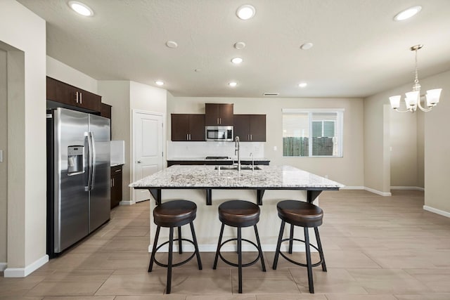 503 Cathedral Ct S, Madera, CA 93636 - kitchen featuring appliances with stainless steel finishes, recessed lighting, dark brown cabinets, and a kitchen breakfast bar