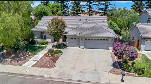 4632 W Minarets Ave, Fresno, CA 93722 - ranch-style house with a tile roof, driveway, an attached garage, and stucco siding
