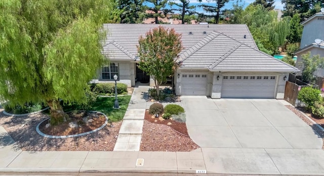 4632 W Minarets Ave, Fresno, CA 93722 - view of front of house with a tiled roof, concrete driveway, and a garage