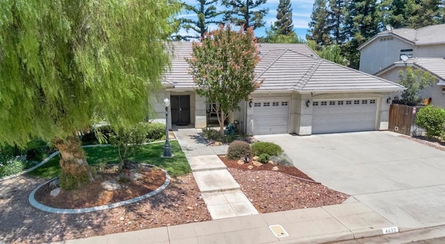 4632 W Minarets Ave, Fresno, CA 93722 - view of front of house featuring a garage, driveway, and a tiled roof