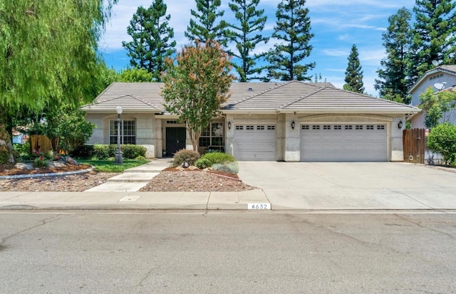 4632 W Minarets Ave, Fresno, CA 93722 - single story home featuring an attached garage, concrete driveway, a tiled roof, and stucco siding