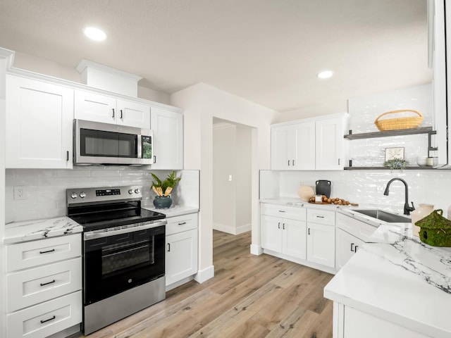 3844 E Holland Ave, Fresno, CA 93726 - kitchen with appliances with stainless steel finishes, tasteful backsplash, white cabinetry, light wood-style flooring, and recessed lighting