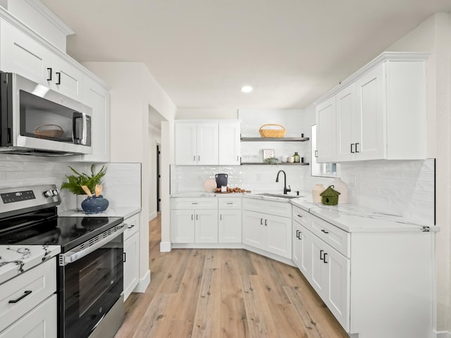 3844 E Holland Ave, Fresno, CA 93726 - kitchen with appliances with stainless steel finishes, backsplash, light wood-style flooring, open shelves, and white cabinetry