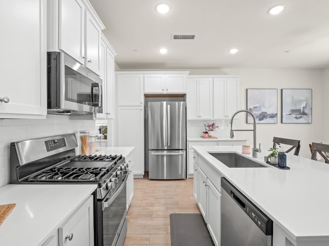 6274 E Riesling Dr, Fresno, CA 93727 - kitchen featuring appliances with stainless steel finishes, white cabinetry, decorative backsplash, light countertops, and recessed lighting
