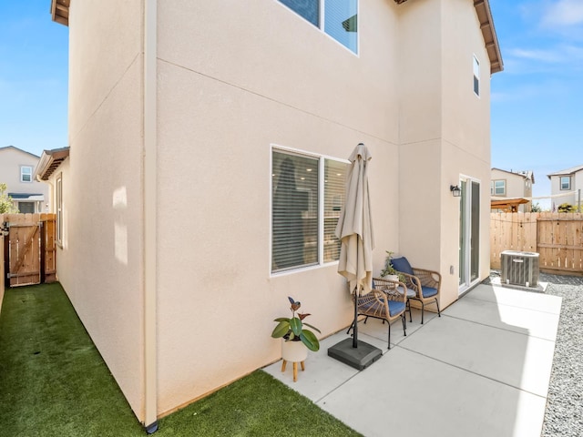6274 E Riesling Dr, Fresno, CA 93727 - rear view of house with stucco siding, a patio area, and a gate