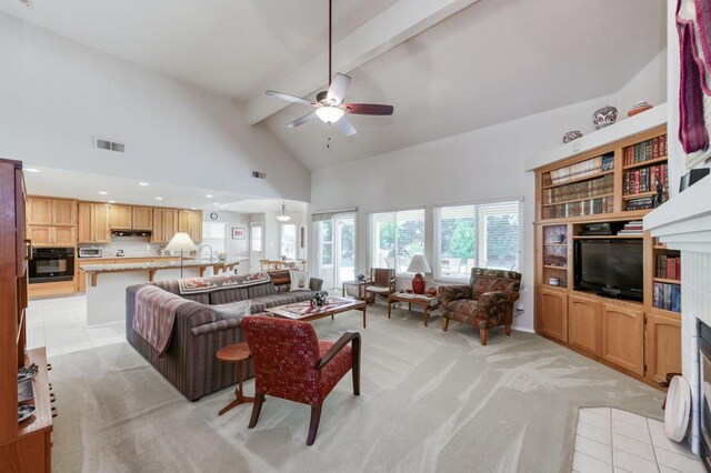 3084 Magnolia Ave, Clovis, CA 93611 - living area with beam ceiling, light carpet, high vaulted ceiling, ceiling fan, and a tiled fireplace