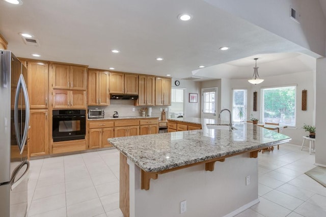 3084 Magnolia Ave, Clovis, CA 93611 - kitchen featuring black appliances, a breakfast bar area, under cabinet range hood, recessed lighting, and tasteful backsplash
