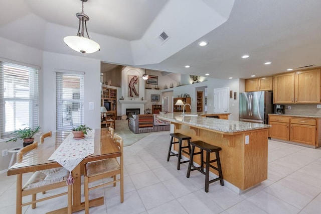 3084 Magnolia Ave, Clovis, CA 93611 - kitchen with freestanding refrigerator, a fireplace, light tile patterned floors, a spacious island, and recessed lighting