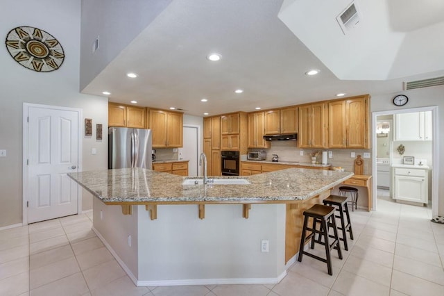 3084 Magnolia Ave, Clovis, CA 93611 - kitchen featuring freestanding refrigerator, oven, recessed lighting, a kitchen breakfast bar, and light tile patterned floors