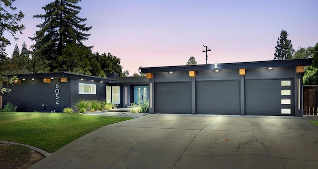 6054 N Kavanagh Ave, Fresno, CA 93711 - contemporary home with driveway, a front lawn, an attached garage, and stucco siding