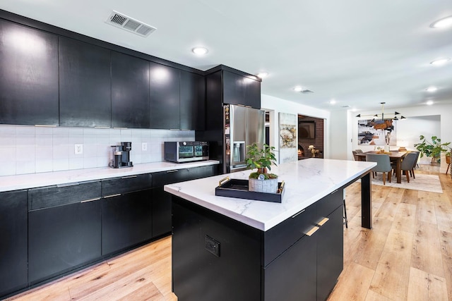 6054 N Kavanagh Ave, Fresno, CA 93711 - kitchen featuring dark cabinets, stainless steel appliances, a kitchen island, backsplash, and recessed lighting