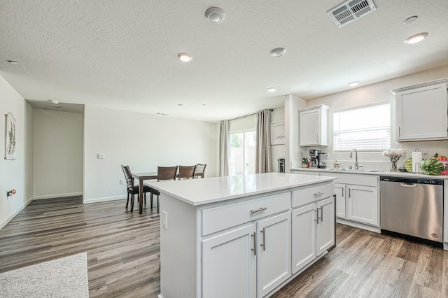 2012 Richard Ave, Sanger, CA 93657 - kitchen with dishwasher, light wood-style floors, a kitchen island, a textured ceiling, and light countertops