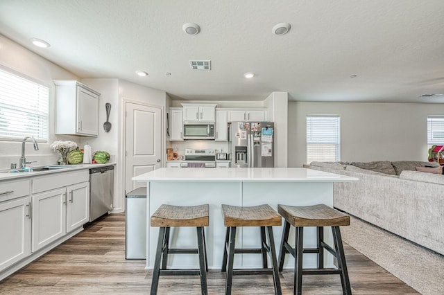 2012 Richard Ave, Sanger, CA 93657 - kitchen with stainless steel appliances, open floor plan, a breakfast bar area, white cabinets, and recessed lighting
