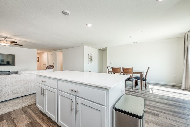 2012 Richard Ave, Sanger, CA 93657 - kitchen with wood finished floors, a kitchen island, open floor plan, ceiling fan, and light countertops