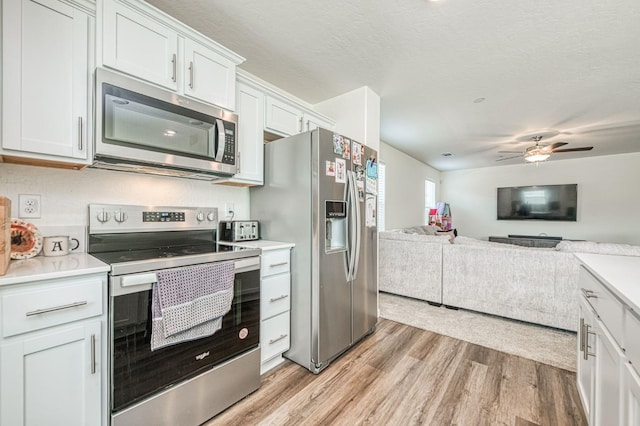 2012 Richard Ave, Sanger, CA 93657 - kitchen featuring appliances with stainless steel finishes, light countertops, light wood-type flooring, and open floor plan