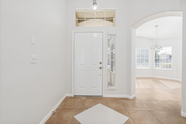 5647 N Tracy Ave, Fresno, CA 93722 - foyer entrance with arched walkways, a chandelier, and light tile patterned floors