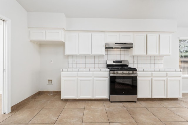 5647 N Tracy Ave, Fresno, CA 93722 - kitchen with stainless steel range with gas cooktop, tile counters, under cabinet range hood, tasteful backsplash, and white cabinets