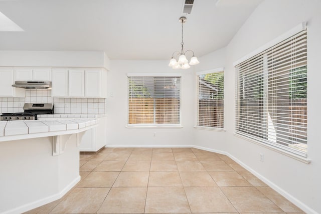 5647 N Tracy Ave, Fresno, CA 93722 - unfurnished dining area with a chandelier and light tile patterned floors