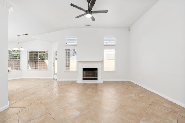 5647 N Tracy Ave, Fresno, CA 93722 - unfurnished living room with a chandelier, ceiling fan, a glass covered fireplace, plenty of natural light, and vaulted ceiling