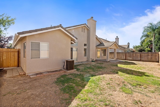 5647 N Tracy Ave, Fresno, CA 93722 - rear view of house featuring a fenced backyard, stucco siding, a chimney, and a patio area