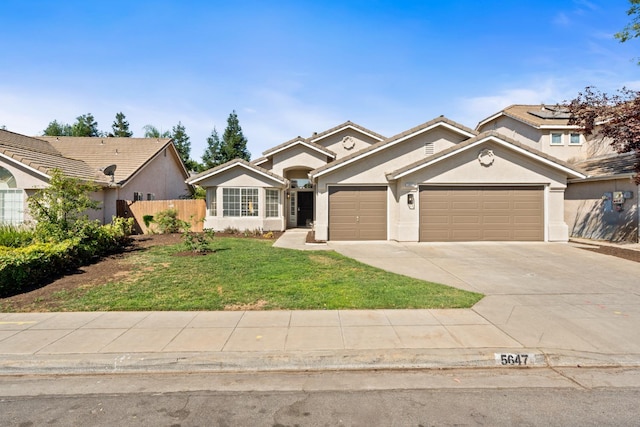 5647 N Tracy Ave, Fresno, CA 93722 - view of front of home featuring a garage, driveway, and stucco siding