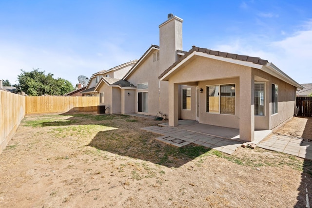 5647 N Tracy Ave, Fresno, CA 93722 - back of house featuring a fenced backyard, a chimney, stucco siding, and a patio