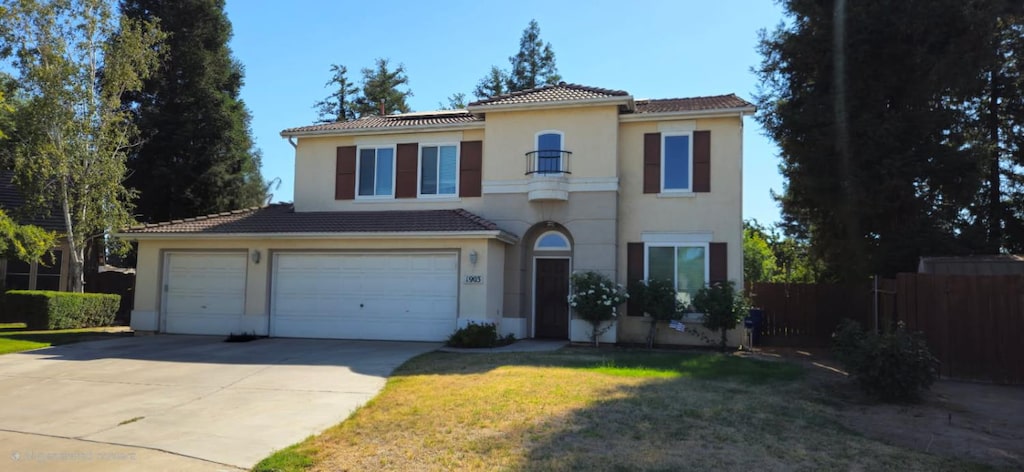 1903 N Sunny Ln E, Reedley, CA 93654 - mediterranean / spanish house featuring stucco siding, a tiled roof, concrete driveway, and an attached garage
