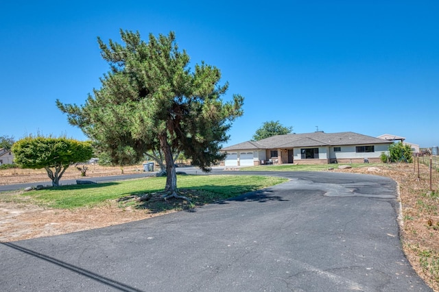 3377 N Bryan Ave, Fresno, CA 93723 - view of front facade with an attached garage, driveway, and a front lawn