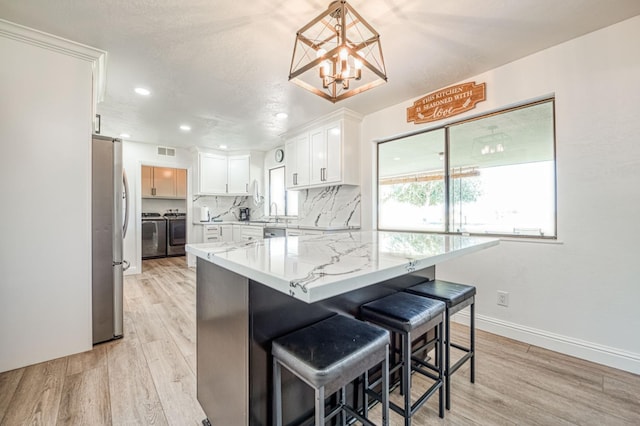 3377 N Bryan Ave, Fresno, CA 93723 - kitchen featuring freestanding refrigerator, white cabinetry, light wood-style floors, light stone countertops, and recessed lighting