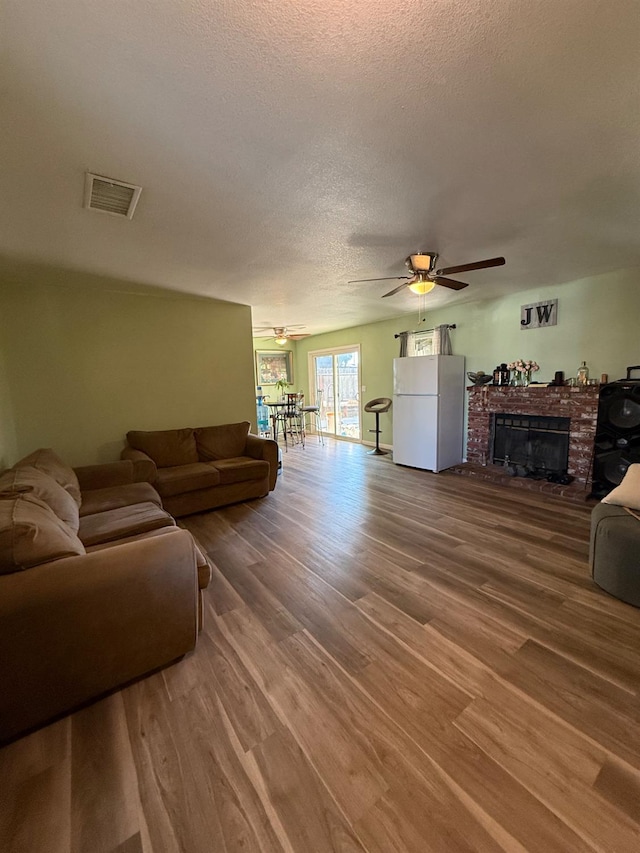 2662 Yerba St, Selma, CA 93662 - living area featuring a ceiling fan, wood finished floors, a textured ceiling, and a fireplace