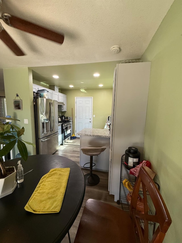 2662 Yerba St, Selma, CA 93662 - kitchen featuring appliances with stainless steel finishes, white cabinetry, wood finished floors, ceiling fan, and a textured ceiling