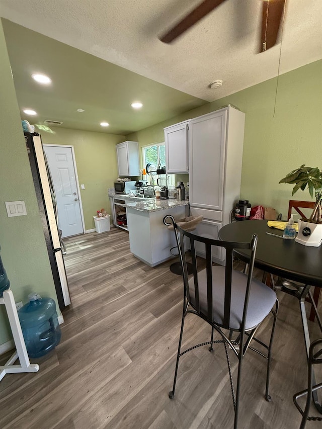 2662 Yerba St, Selma, CA 93662 - kitchen with a peninsula, white cabinetry, wood finished floors, stainless steel appliances, and recessed lighting