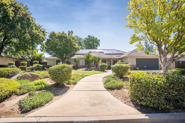 6372 N Benedict Ave, Fresno, CA 93711 - single story home with roof mounted solar panels, stucco siding, and an attached garage