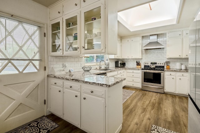 6372 N Benedict Ave, Fresno, CA 93711 - kitchen featuring stainless steel range with electric cooktop, wall chimney exhaust hood, light wood finished floors, and white cabinets