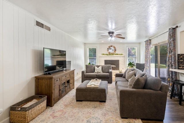 6372 N Benedict Ave, Fresno, CA 93711 - living area with a ceiling fan, a fireplace, wood finished floors, and a textured ceiling