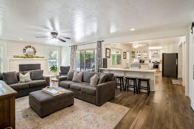 6372 N Benedict Ave, Fresno, CA 93711 - living area featuring a ceiling fan, dark wood-style flooring, a textured ceiling, and a fireplace