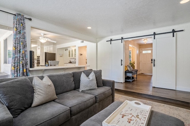 6372 N Benedict Ave, Fresno, CA 93711 - living room featuring a barn door, wood finished floors, a textured ceiling, ceiling fan, and recessed lighting