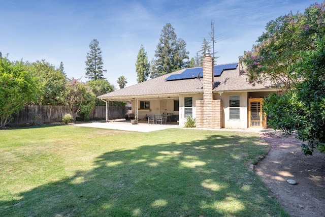 6372 N Benedict Ave, Fresno, CA 93711 - rear view of property with roof mounted solar panels, a fenced backyard, a patio, a chimney, and stucco siding