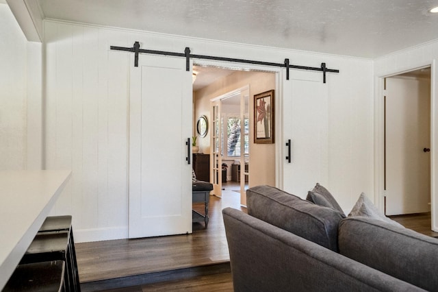 6372 N Benedict Ave, Fresno, CA 93711 - living area with a barn door, dark wood-style flooring, and ornamental molding