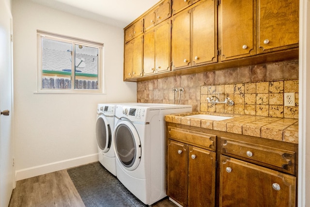 6372 N Benedict Ave, Fresno, CA 93711 - laundry room featuring cabinet space, washer and clothes dryer, and wood finished floors