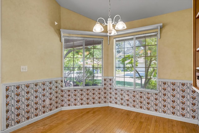 1210 E Province Dr, Fresno, CA 93720 - empty room with a wainscoted wall, light wood-type flooring, a chandelier, wallpapered walls, and lofted ceiling