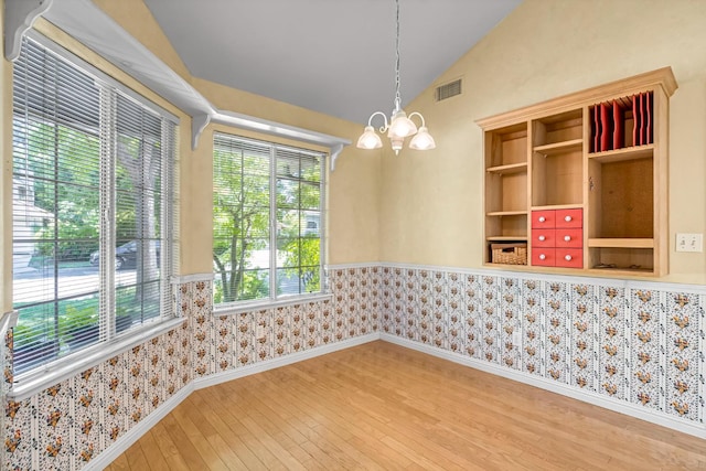 1210 E Province Dr, Fresno, CA 93720 - empty room featuring a chandelier, hardwood / wood-style floors, vaulted ceiling, and wallpapered walls