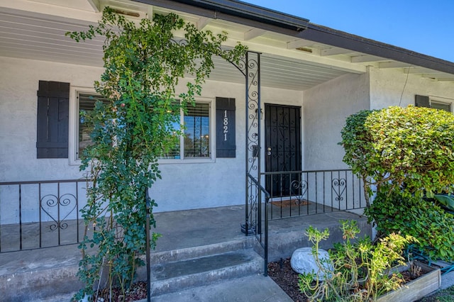 1821 W Lansing Way, Fresno, CA 93705 - doorway to property with covered porch and stucco siding