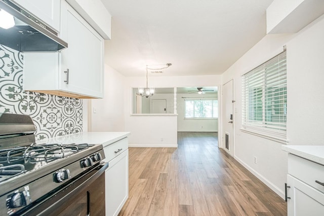 1821 W Lansing Way, Fresno, CA 93705 - kitchen with range with gas stovetop, under cabinet range hood, white cabinets, light countertops, and light wood-style floors