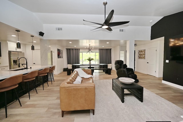 25190 Elwood Rd, Sanger, CA 93657 - living area featuring light wood finished floors, vaulted ceiling, ceiling fan, a chandelier, and recessed lighting