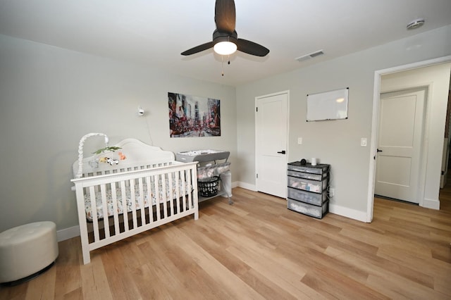 25190 Elwood Rd, Sanger, CA 93657 - bedroom featuring light wood-type flooring, a nursery area, and ceiling fan