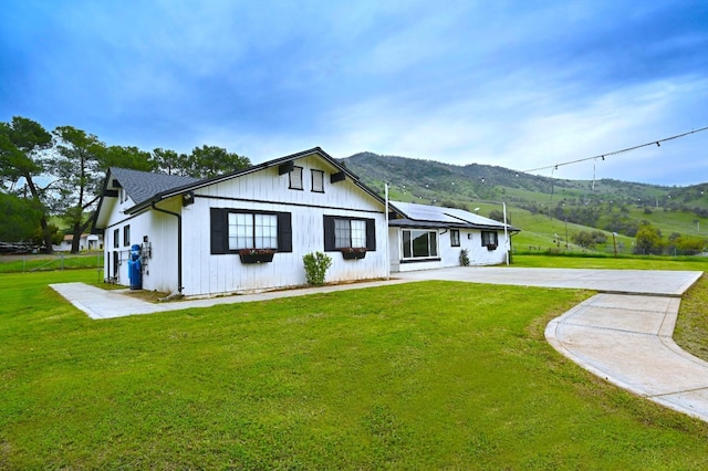 25190 Elwood Rd, Sanger, CA 93657 - modern inspired farmhouse featuring solar panels, a mountain view, a front lawn, and concrete driveway